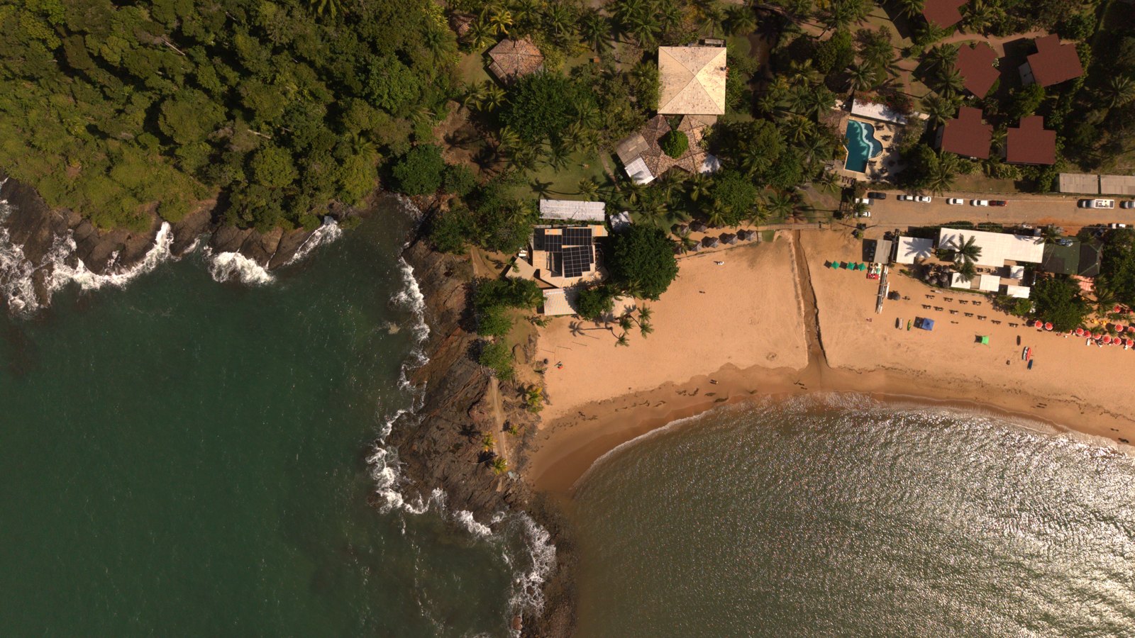 Praia da Concha vista de cima, com a ponta de pedras, a mata e a orla de Itacaré